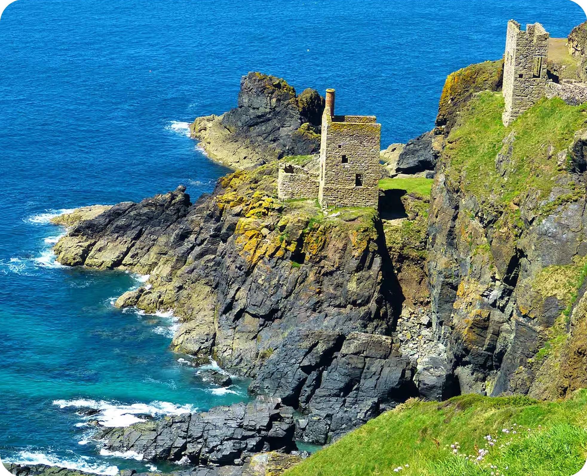 Ruins of Botallack Mine perched on rugged cliffs by the sea in Cornwall, England.