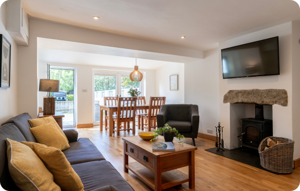 Modern living and dining area with cozy furnishings, fireplace, and large windows for natural light.