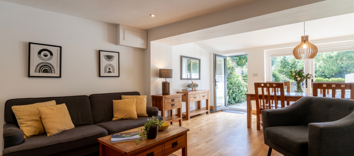 Modern living and dining area with natural light, stylish decor, and open outdoor access.